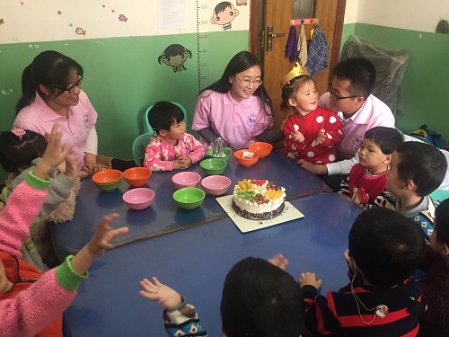 志愿者为当天过生日的孩子庆祝生日